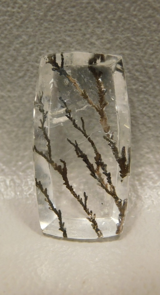 A rectangle of clear quartz with vertical gray veins running through it.
