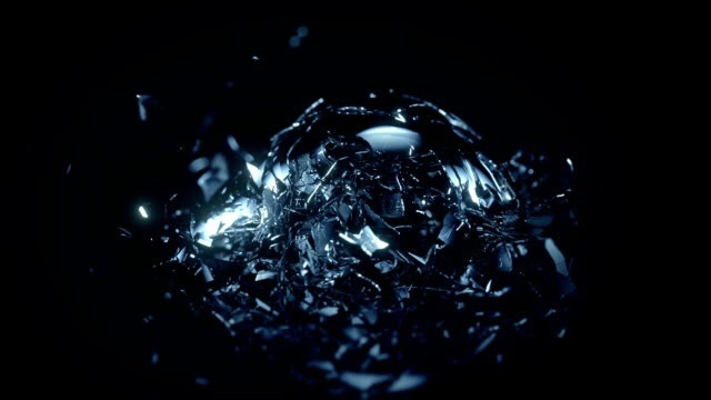 A black background with a picture of shattered blue-tinted glass, the shards of the glass suggest a spherical shape to the original object